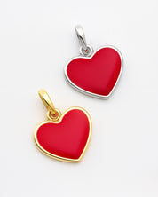 Two heart-shaped pendants, one gold and one silver, on a light gray background.