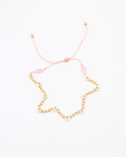 Beaded bracelet in light pink, white and gold tones with a zigzag pattern and adjustable sliding closure, laid flat on a white background.