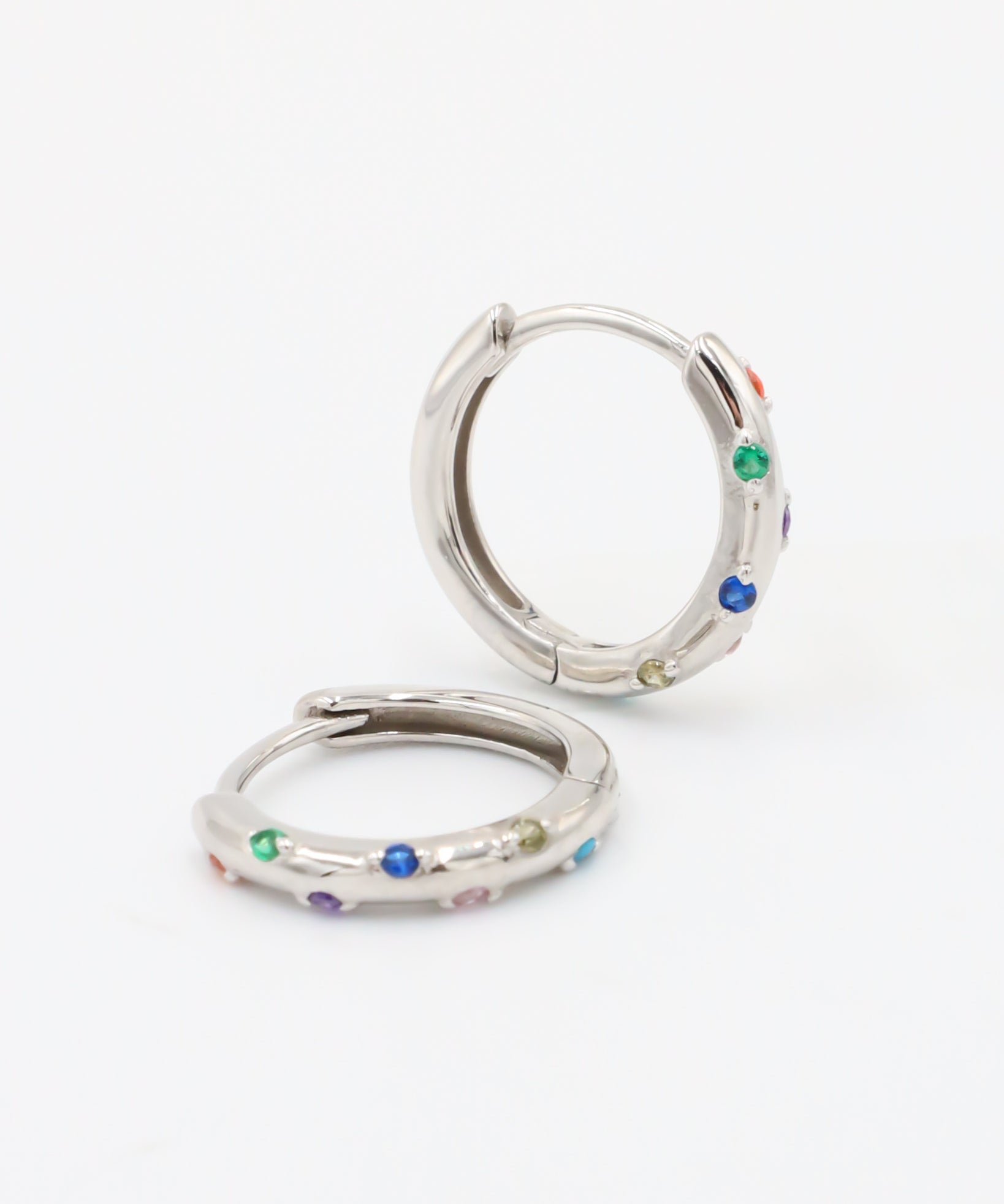 A pair of silver-colored hoop earrings with multicolored accents, displayed against a white background.