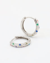 A pair of silver-colored hoop earrings with multicolored accents, displayed against a white background.
