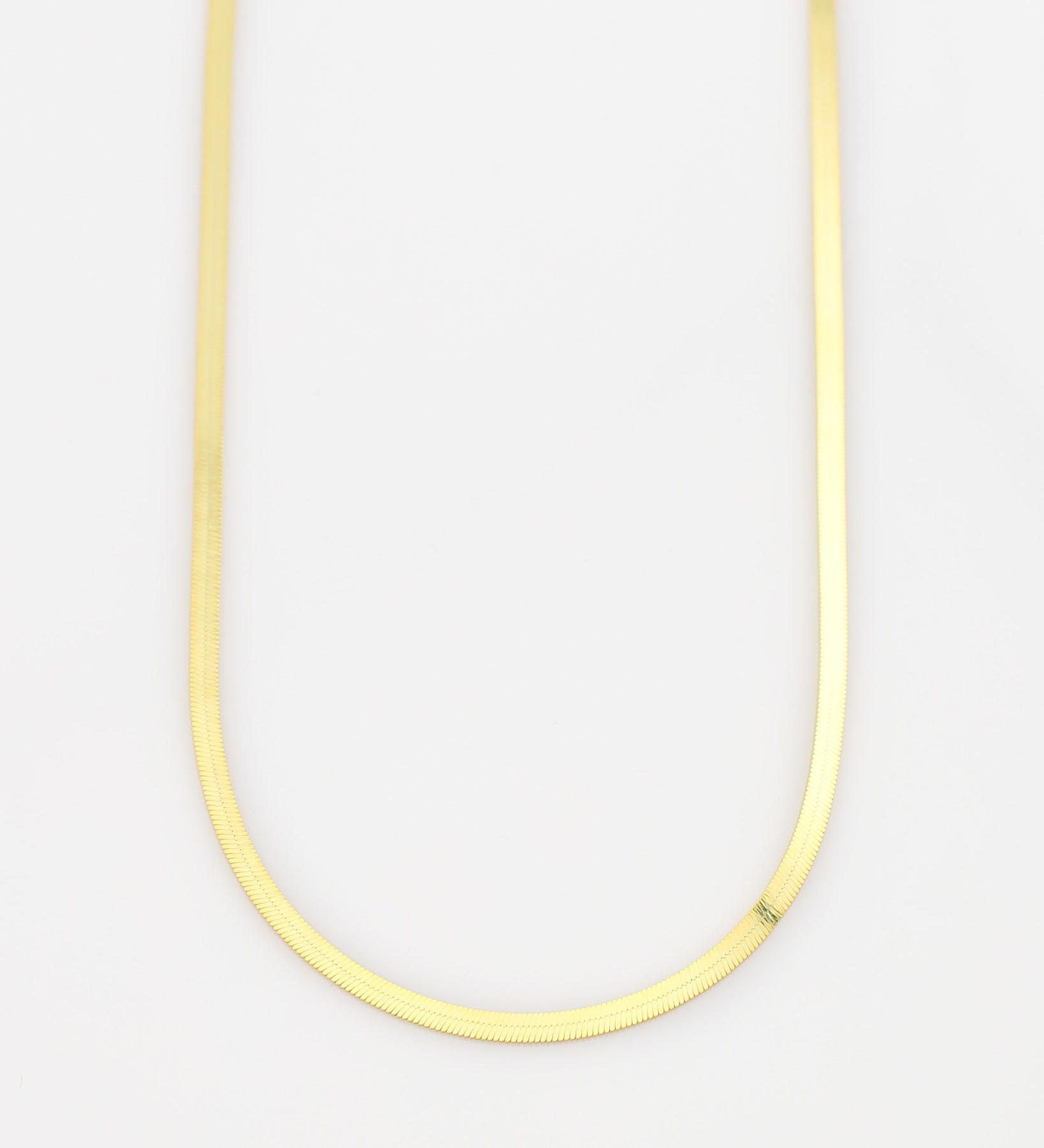 Thin yellow necklace on a light gray background