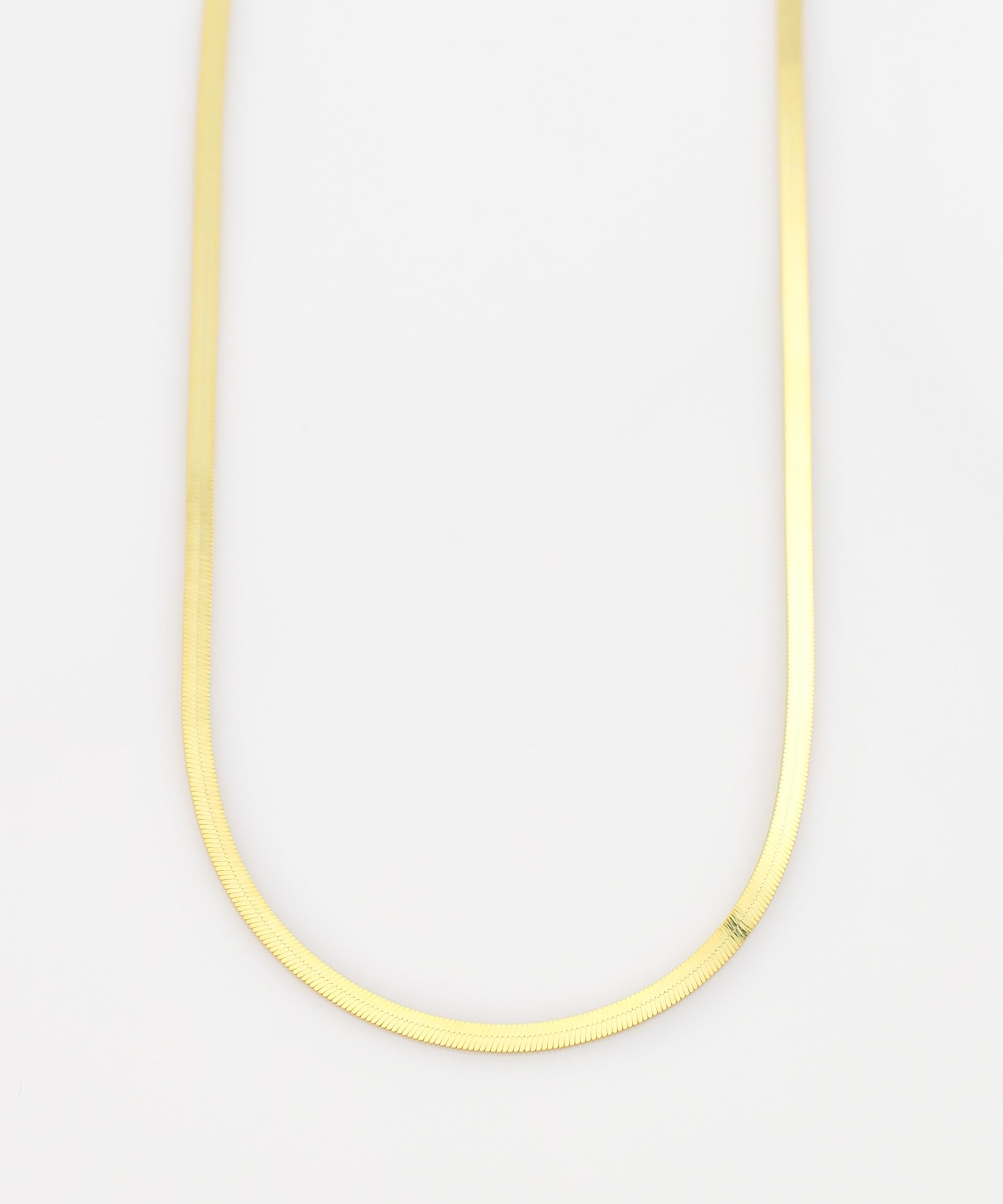 Thin yellow necklace on a light gray background