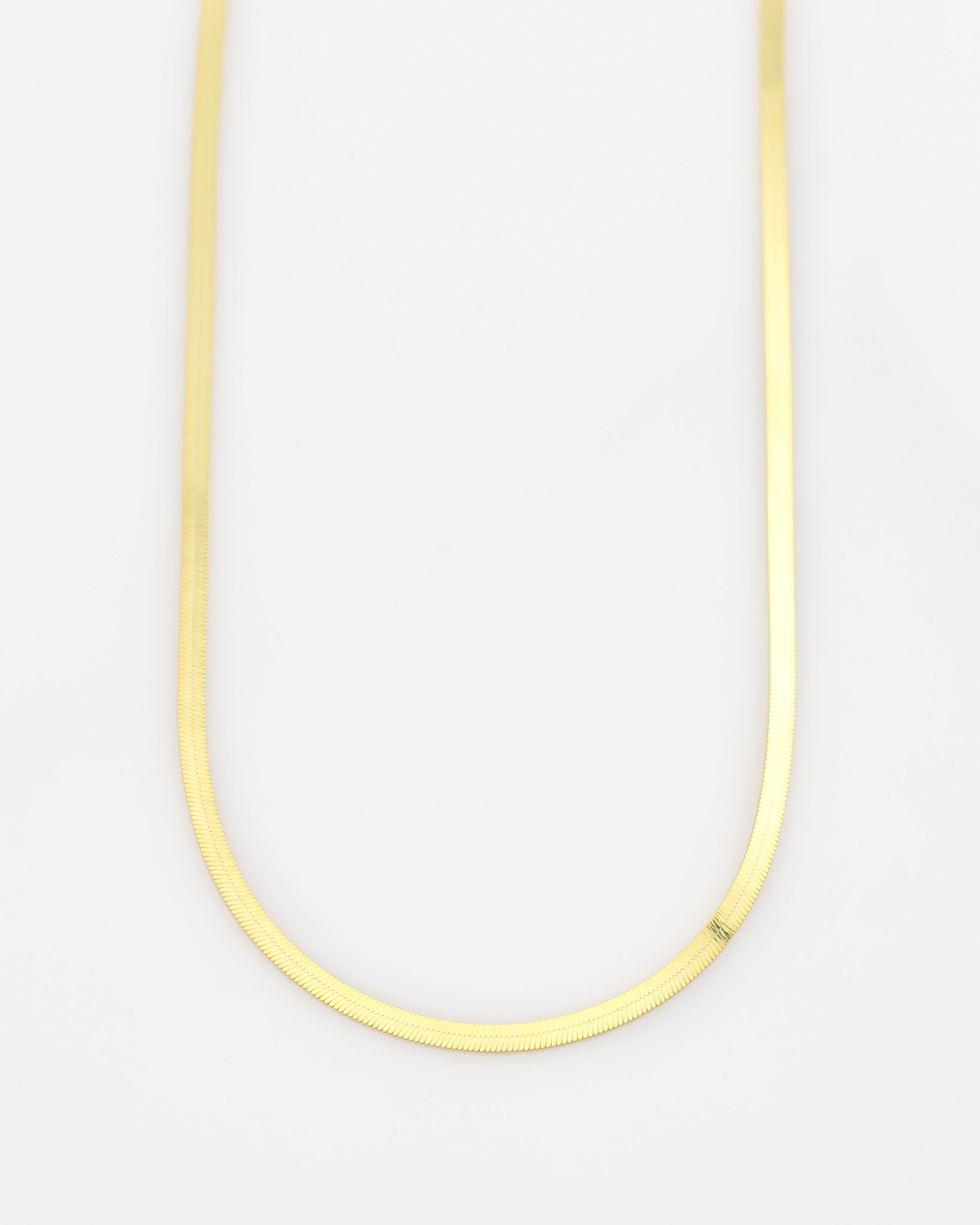 Thin yellow necklace on a light gray background