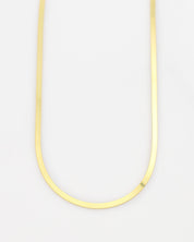 Thin yellow necklace on a light gray background