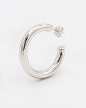 A pair of silver hoop earrings with a visible stud attachment, displayed against a white background.