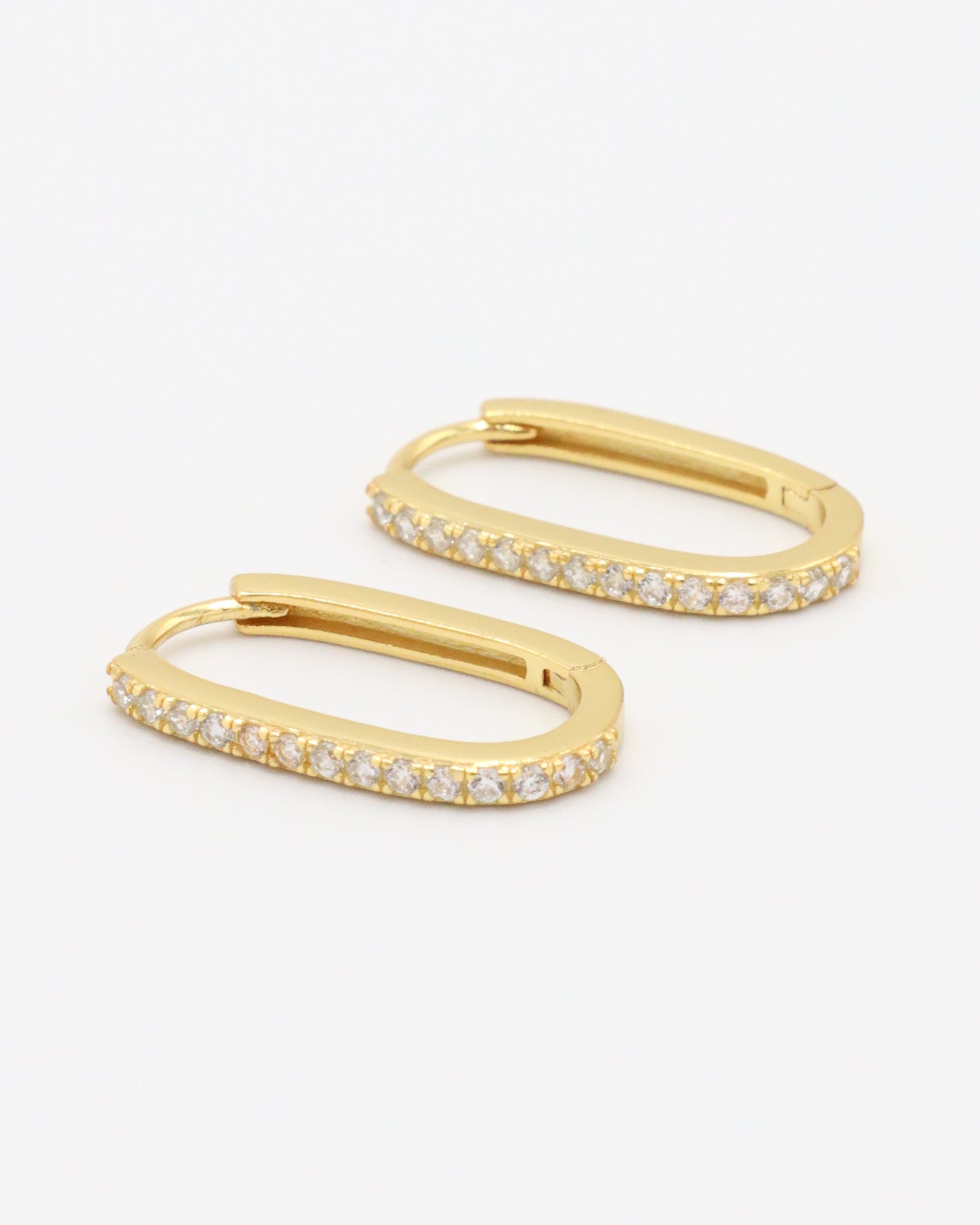 Gold colored hoop earring with a row of inset stones on the hoop, displayed against a white background.