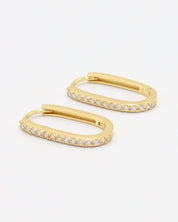 Gold colored hoop earring with a row of inset stones on the hoop, displayed against a white background.