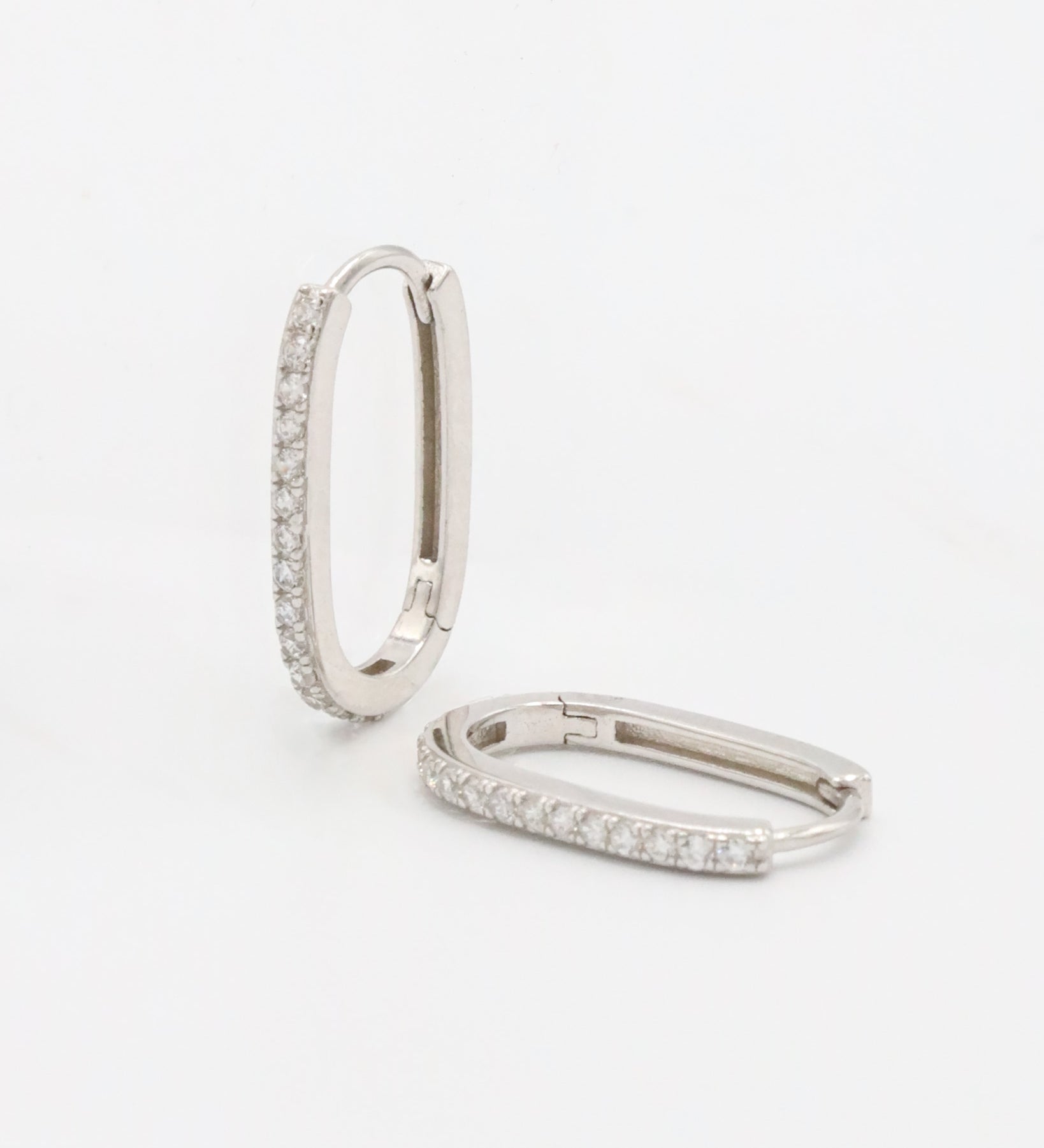 Silver hoop earring with a row of inset stones on the hoop, displayed against a white background.