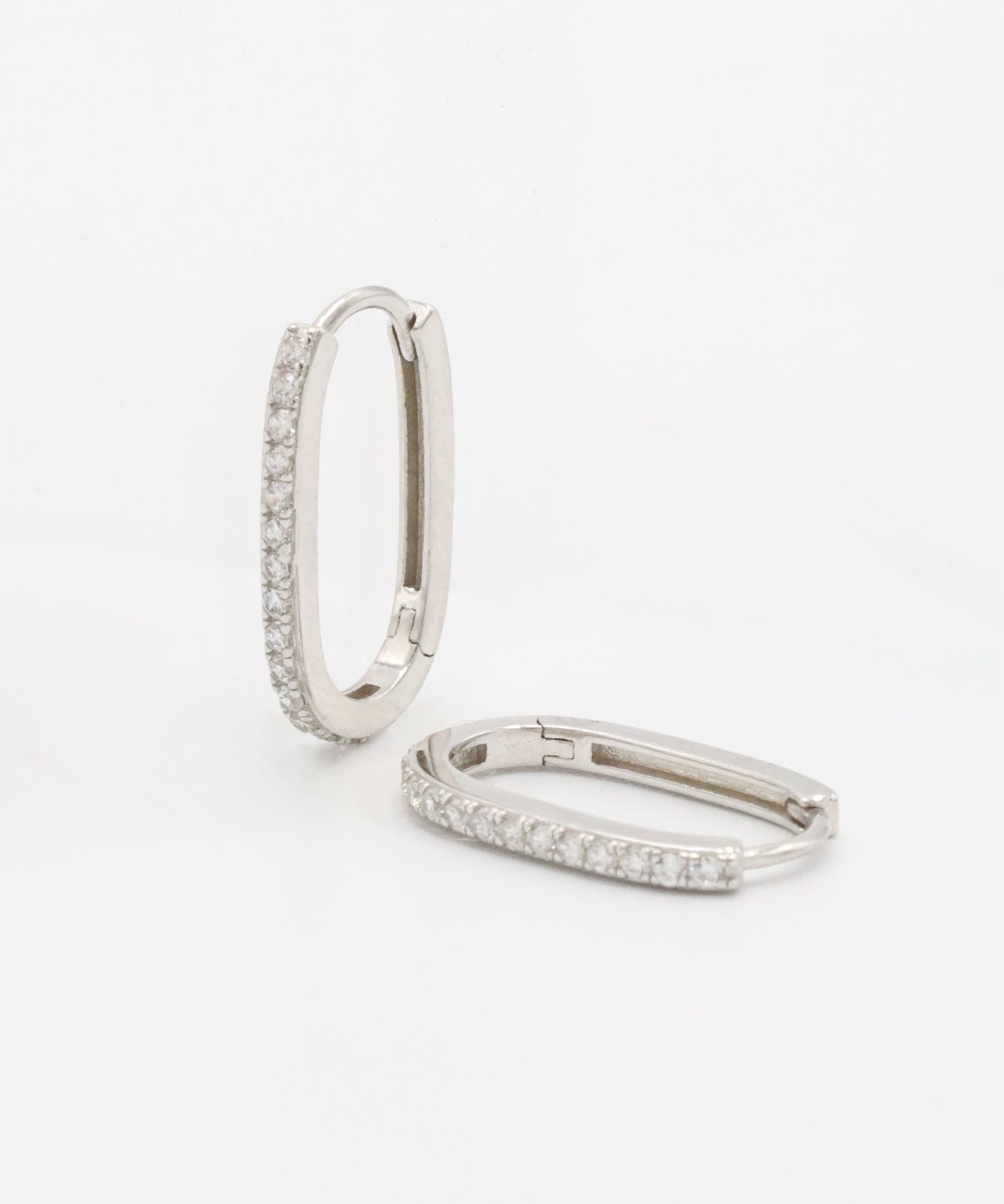 Silver hoop earring with a row of inset stones on the hoop, displayed against a white background.