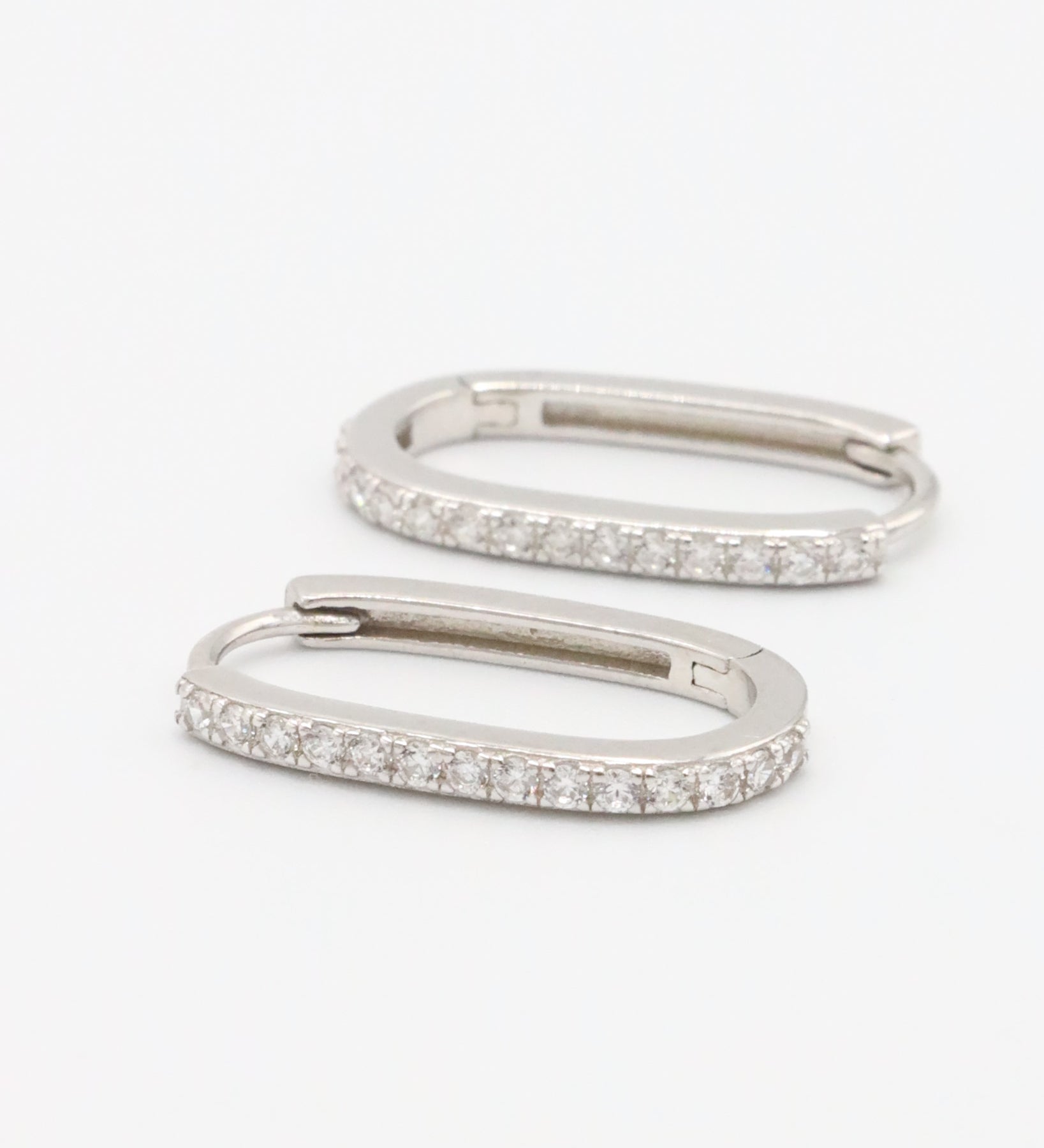 Silver hoop earring with a row of inset stones on the hoop, displayed against a white background.