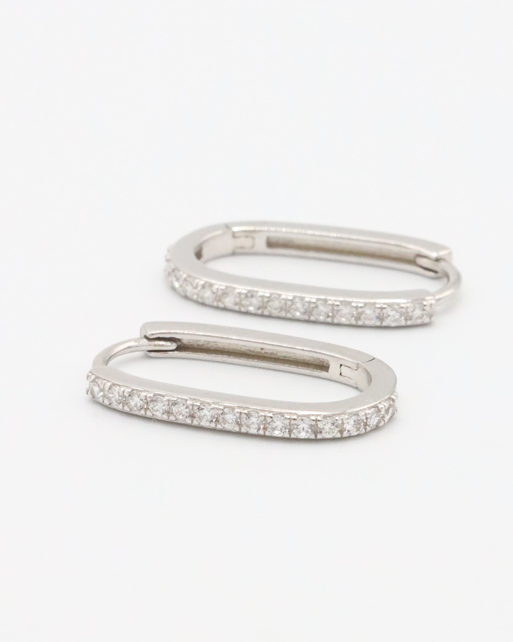 Silver hoop earring with a row of inset stones on the hoop, displayed against a white background.