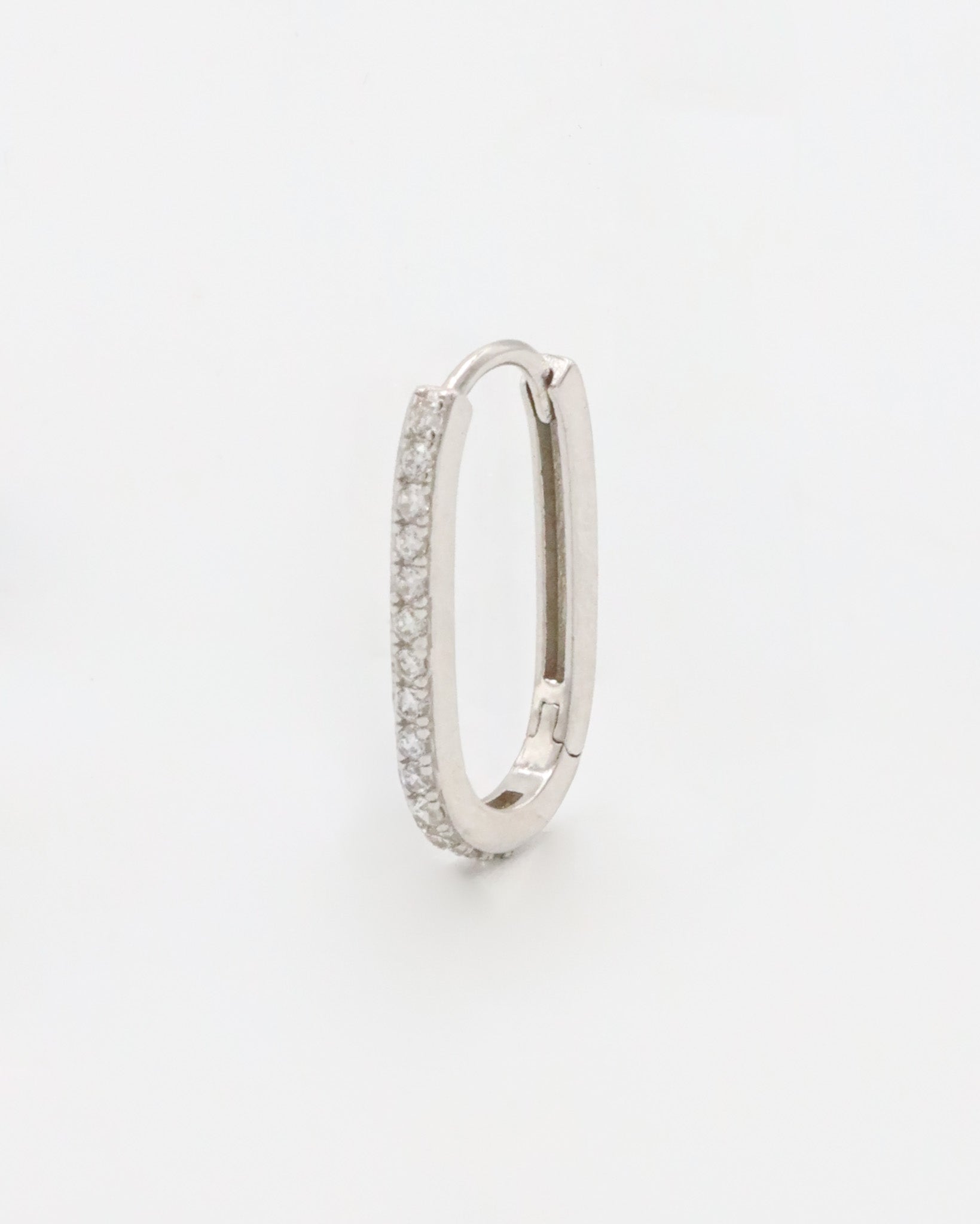 Silver colored hoop earring with a row of inset stones on the hoop, displayed against a white background.