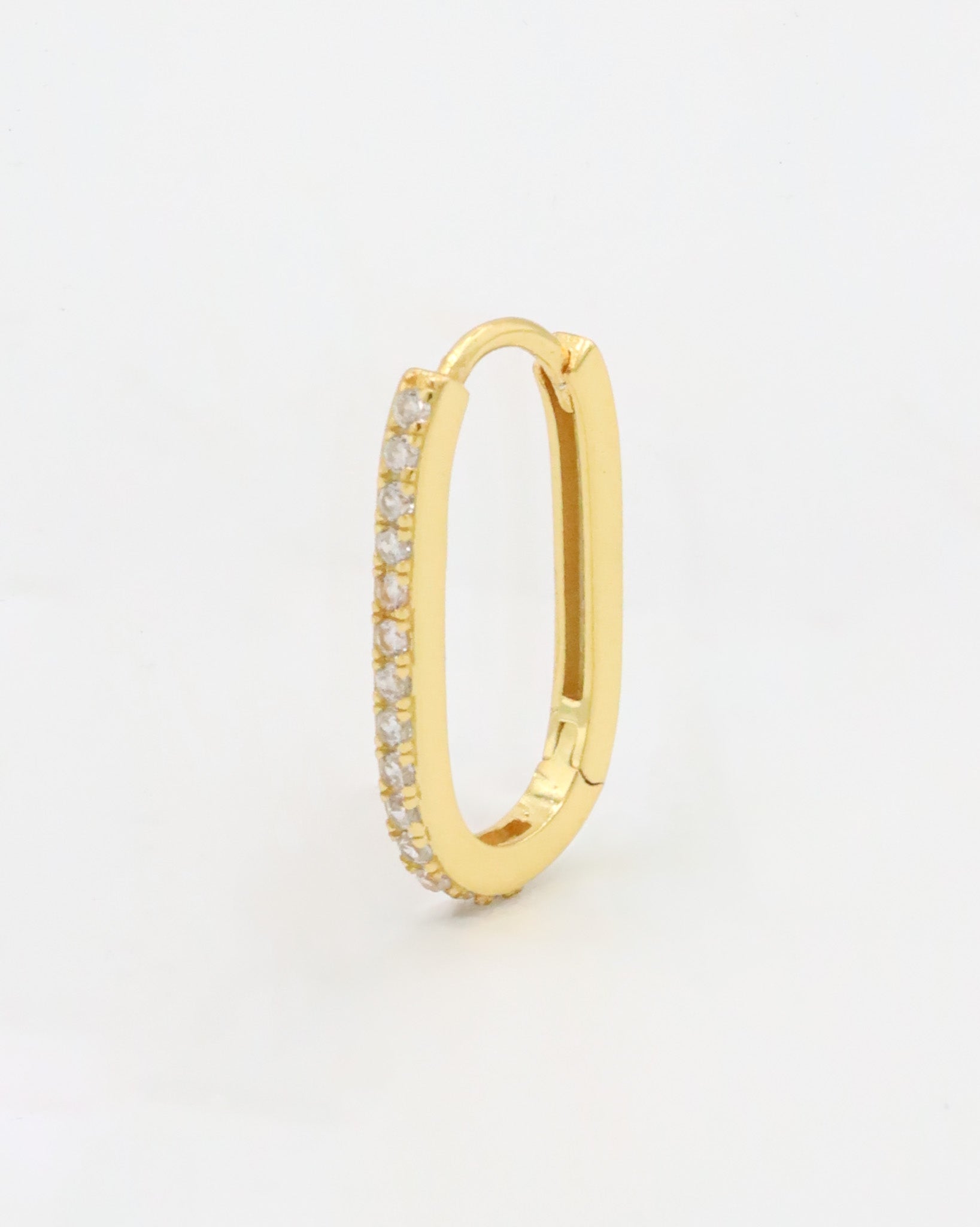 Gold colored hoop earring with a row of inset stones on the hoop, displayed against a white background.