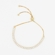 Adjustable gold-colored bracelet with round charms linked together on a white background.