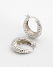A pair of silver hoop earrings with a textured design, displayed against a white background.