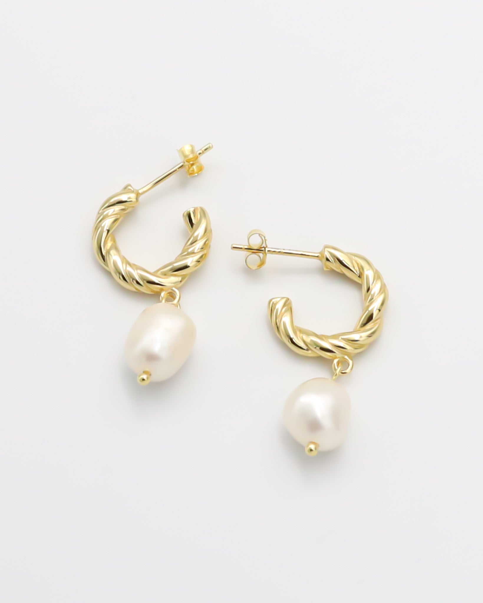 A pair of gold-colored hoop earrings with white pearl accents.