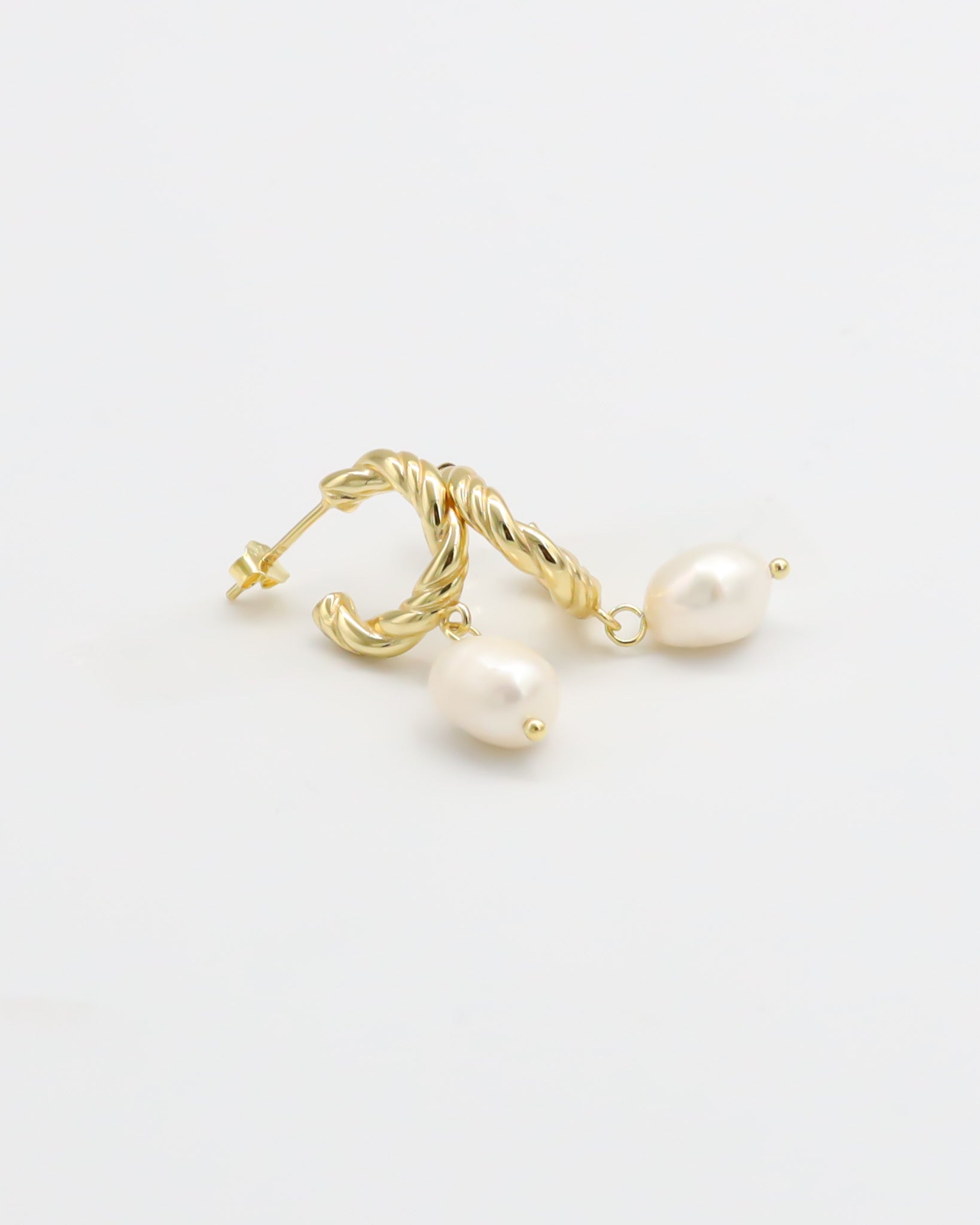 A pair of gold-colored hoop earrings with white pearl accents.