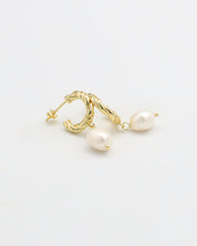 A pair of gold-colored hoop earrings with white pearl accents.