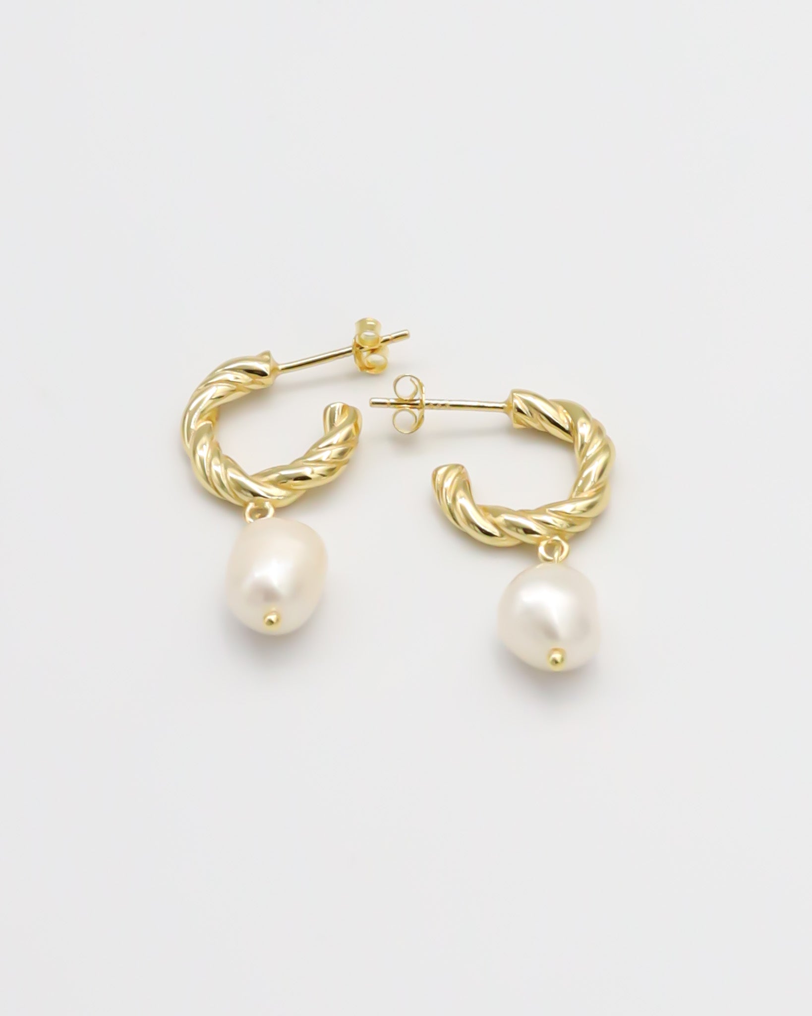 A pair of gold-colored hoop earrings with white pearl accents.