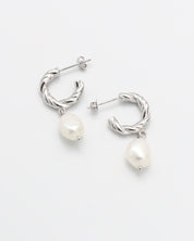 A pair of silver hoop earrings with white pearl studs.