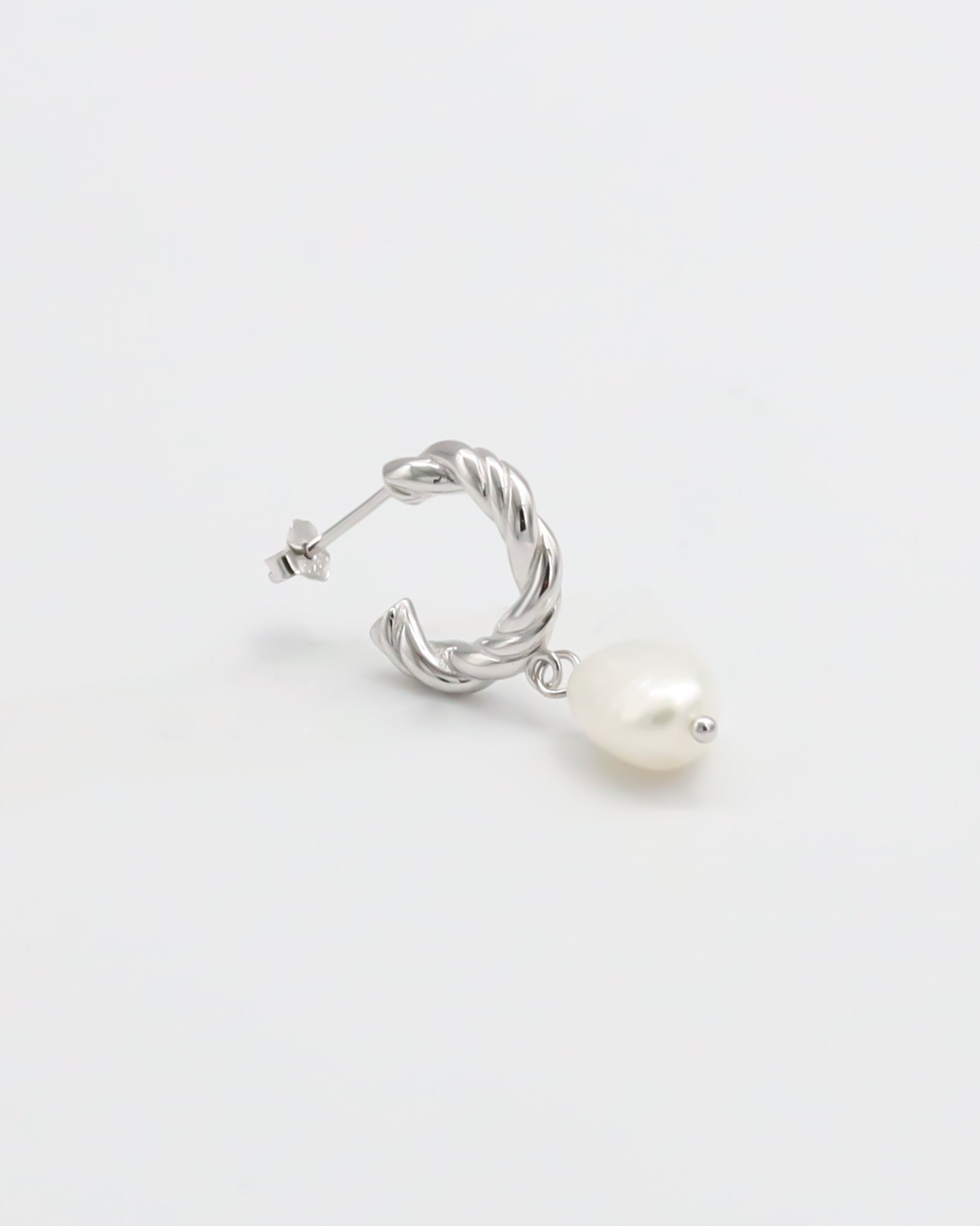A single silver hoop earring with white pearl stud.