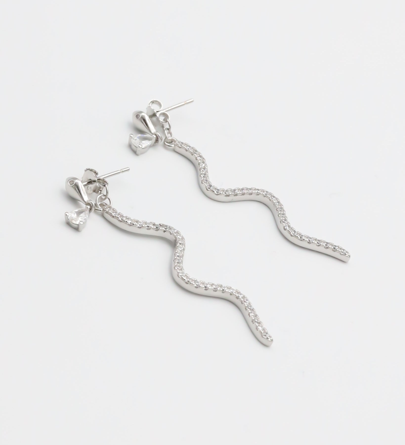 A pair of silver hoop earrings with a serpentine design, featuring a pressure system for anchoring.