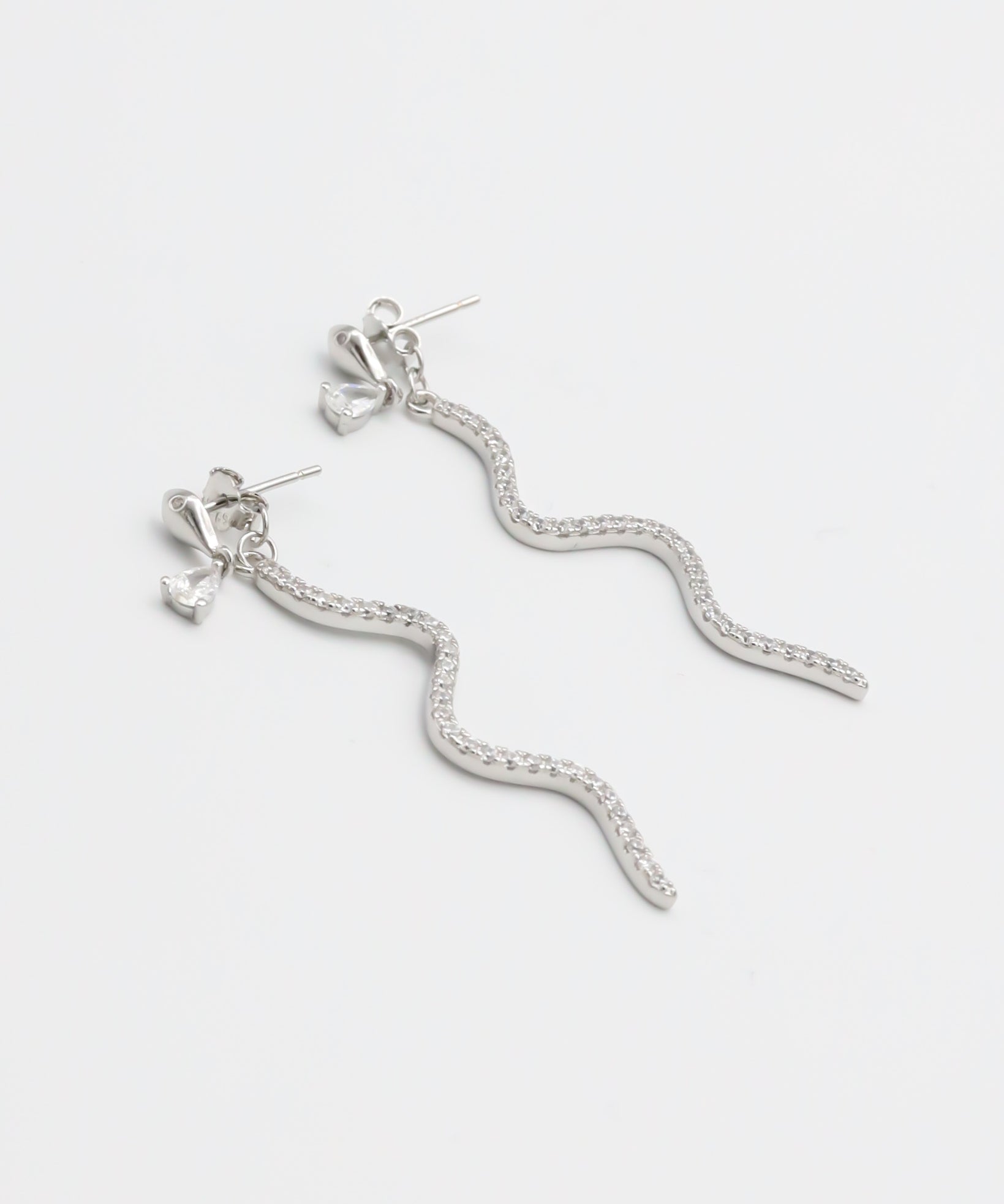 A pair of silver hoop earrings with a serpentine design, featuring a pressure system for anchoring.