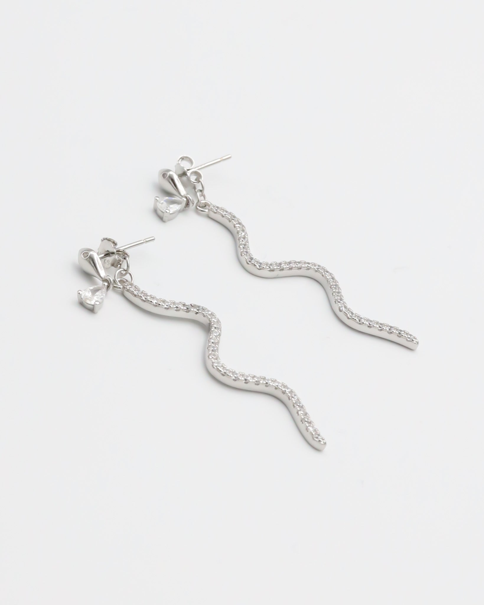 A pair of silver hoop earrings with a serpentine design, featuring a pressure system for anchoring.