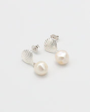 A pair of silver hoop earrings with white pearl accents on a white background.