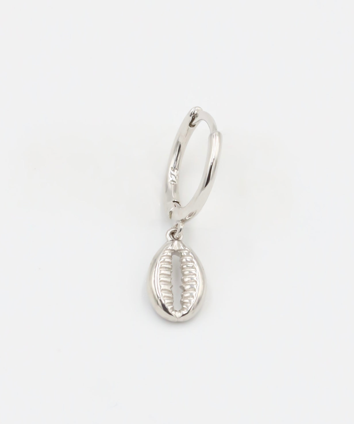 A single silver hoop earring with a small dangling silver charm on a white background