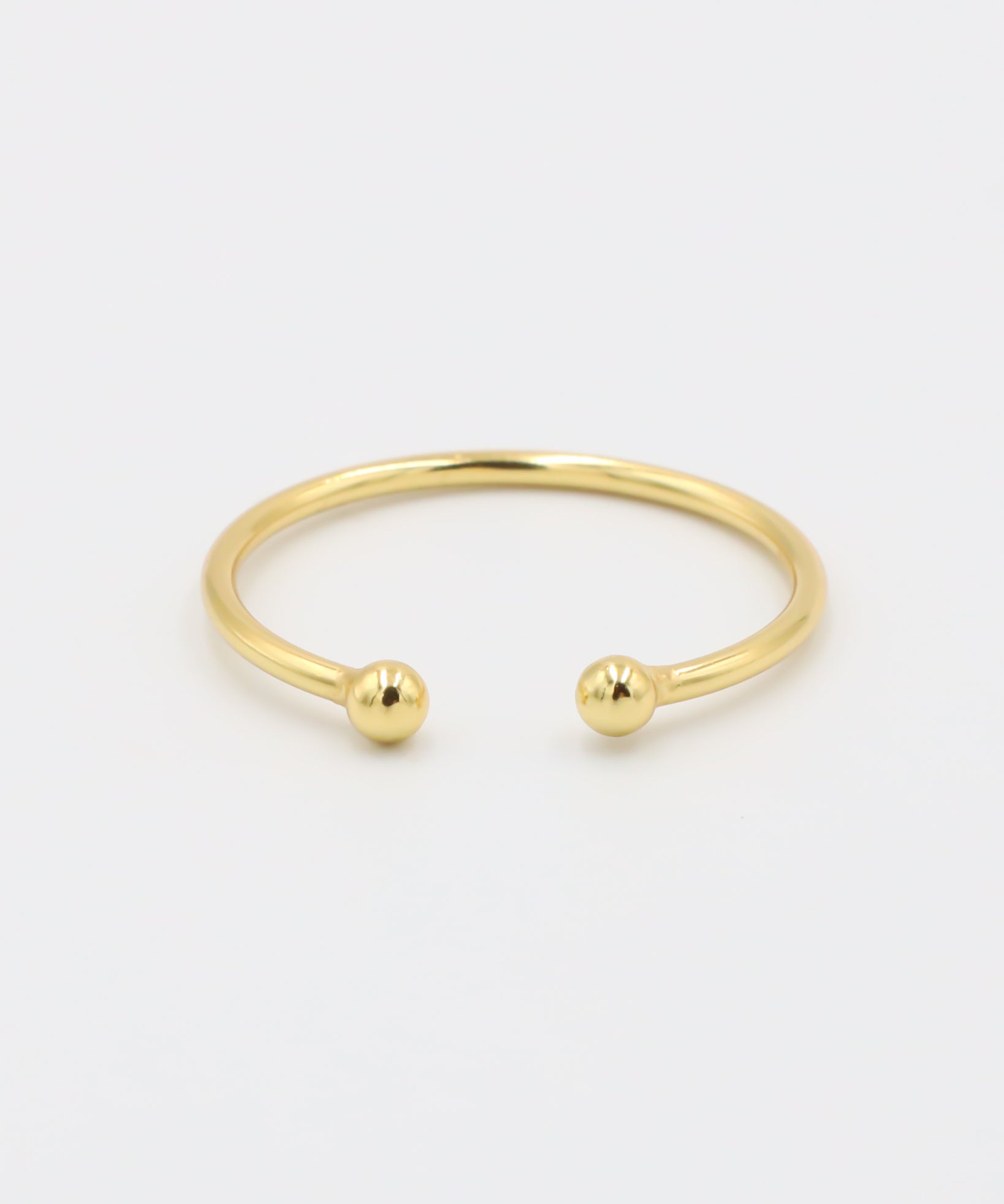 A simple gold-colored ring with two spherical decorations, displayed against a white background.