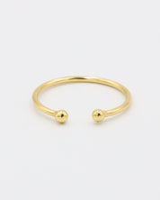A simple gold-colored ring with two spherical decorations, displayed against a white background.