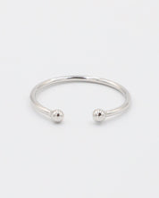 A simple silver bracelet with an adjustable band and small spherical embellishments at the ends.