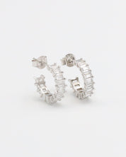 A pair of silver hoop earrings with a textured surface, displayed against a white background.
