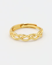 A gold-colored ring with a geometric pattern on a white background