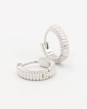 A pair of silver hoop earrings with a textured surface, displayed against a white background.