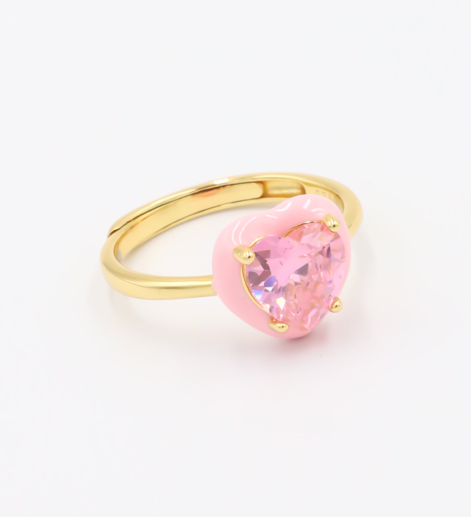 A gold-plated band ring with a pink quartz stone in the center.
