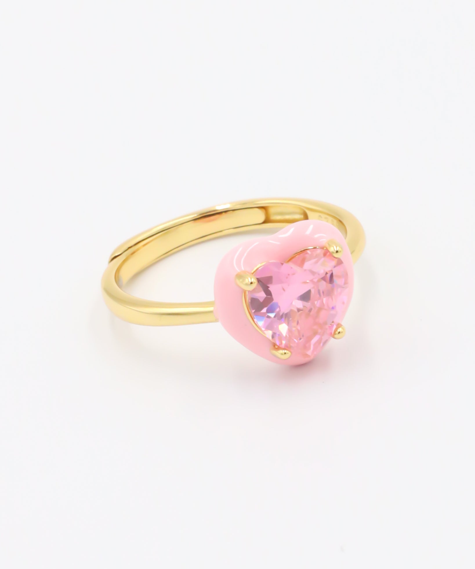 A gold-plated band ring with a pink quartz stone in the center.