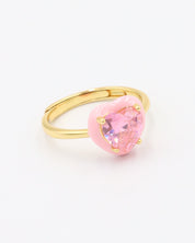 A gold-plated band ring with a pink quartz stone in the center.