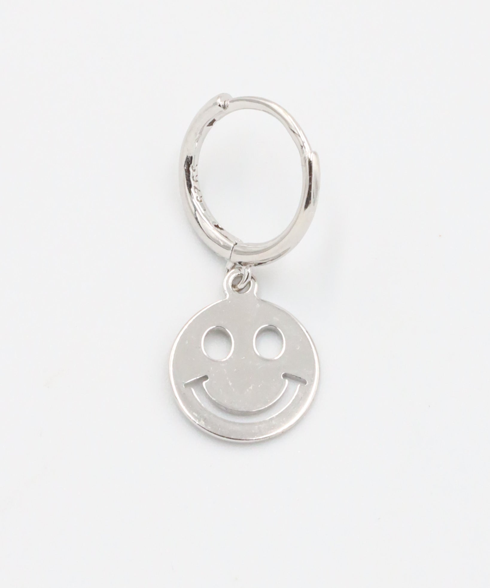 A silver hoop charm with a smiley face design on it.