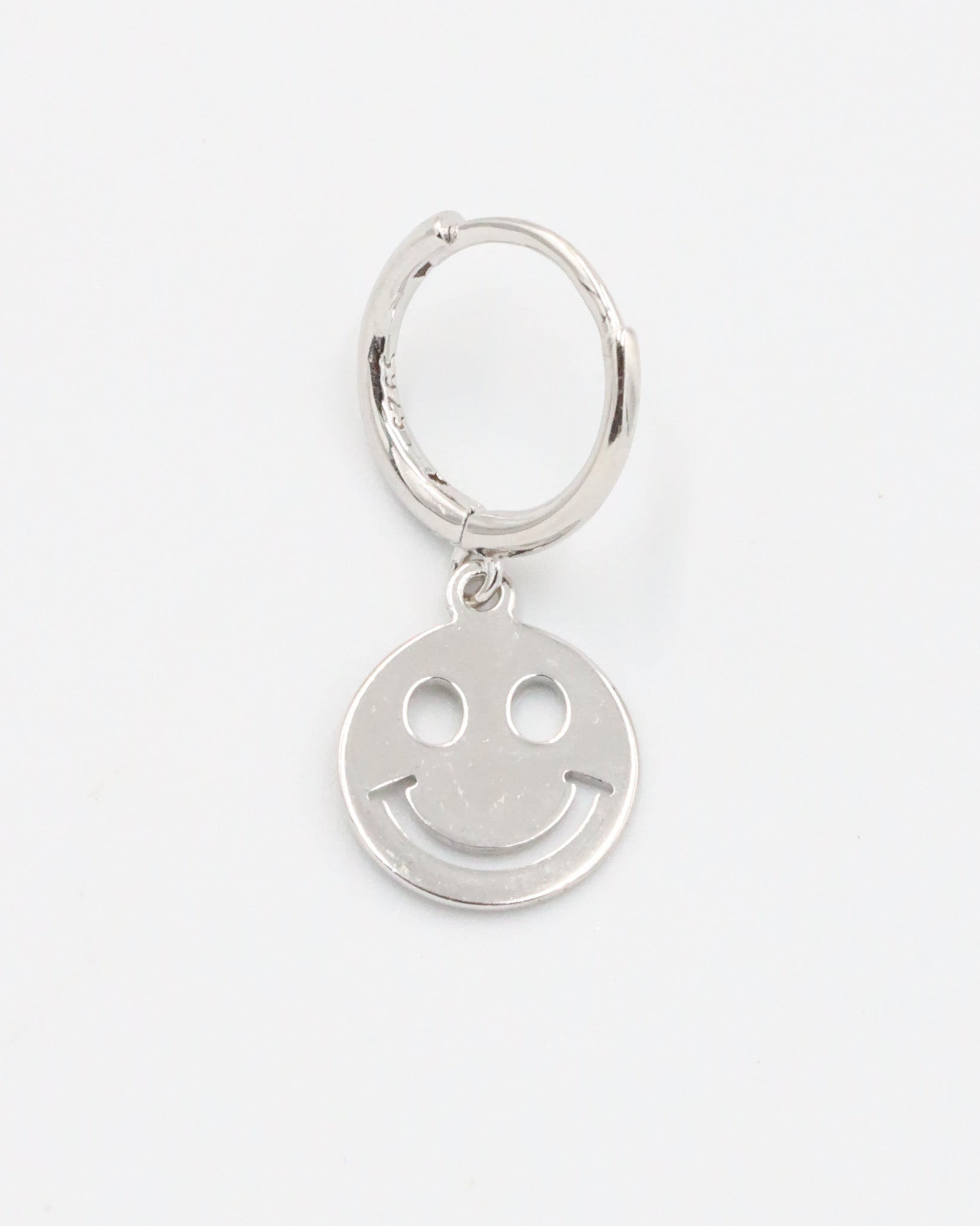 A silver hoop charm with a smiley face design on it.