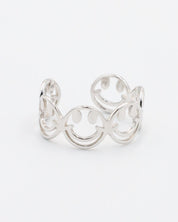 A silver ring with a design featuring multiple smiling face motifs.