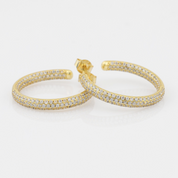 Gold hoop earrings with clear gemstones on a white background