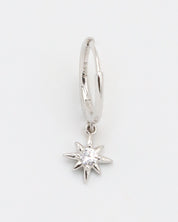 A silver hoop earring with a small star-shaped charm dangling from it.