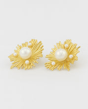 Gold earrings with pearl centers on a white background