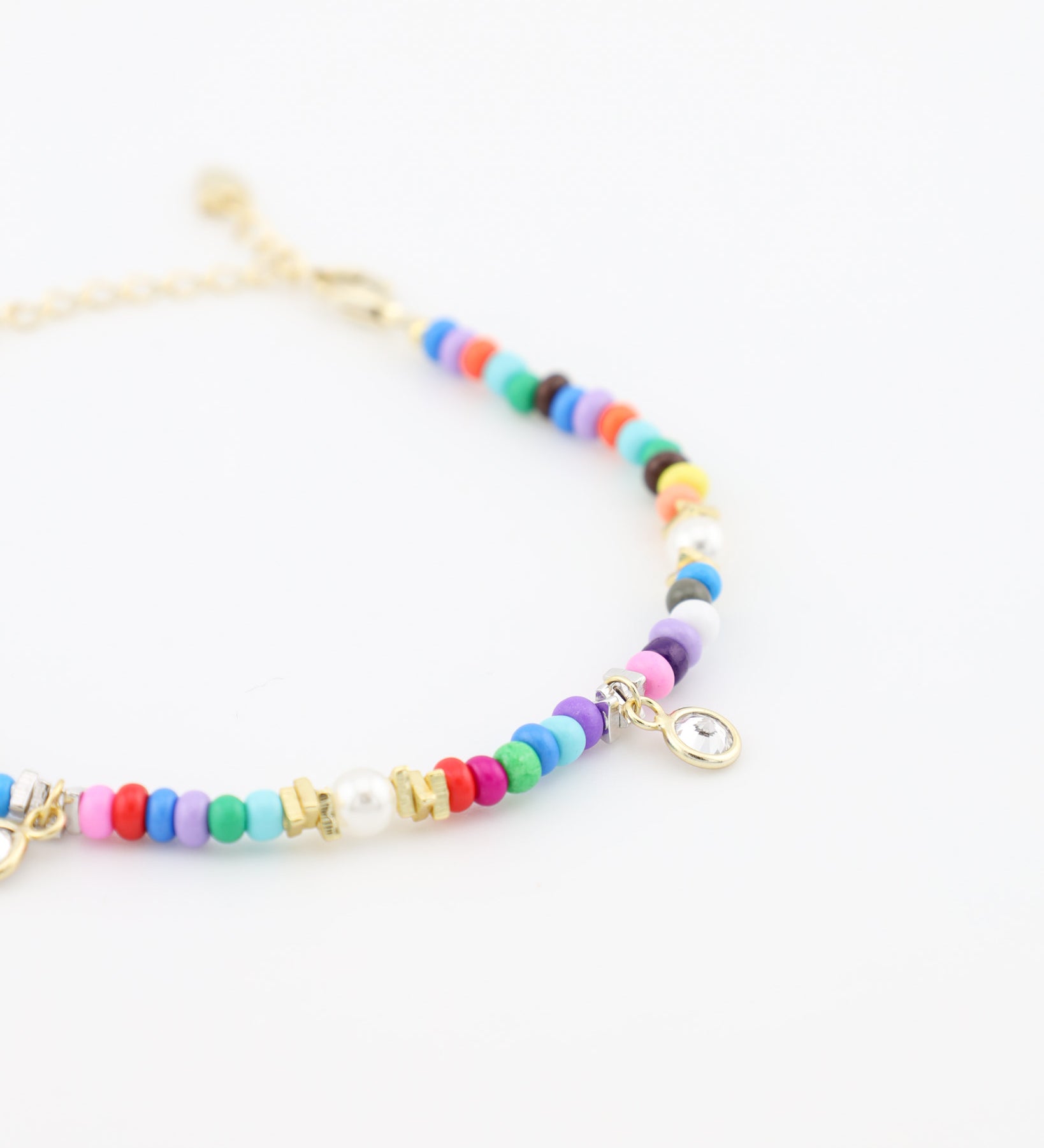 Colorful beaded bracelet with gold accents on a white background