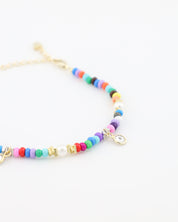 Colorful beaded bracelet with gold accents on a white background