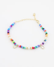 Multicolored beaded bracelet with gold accents on a white background
