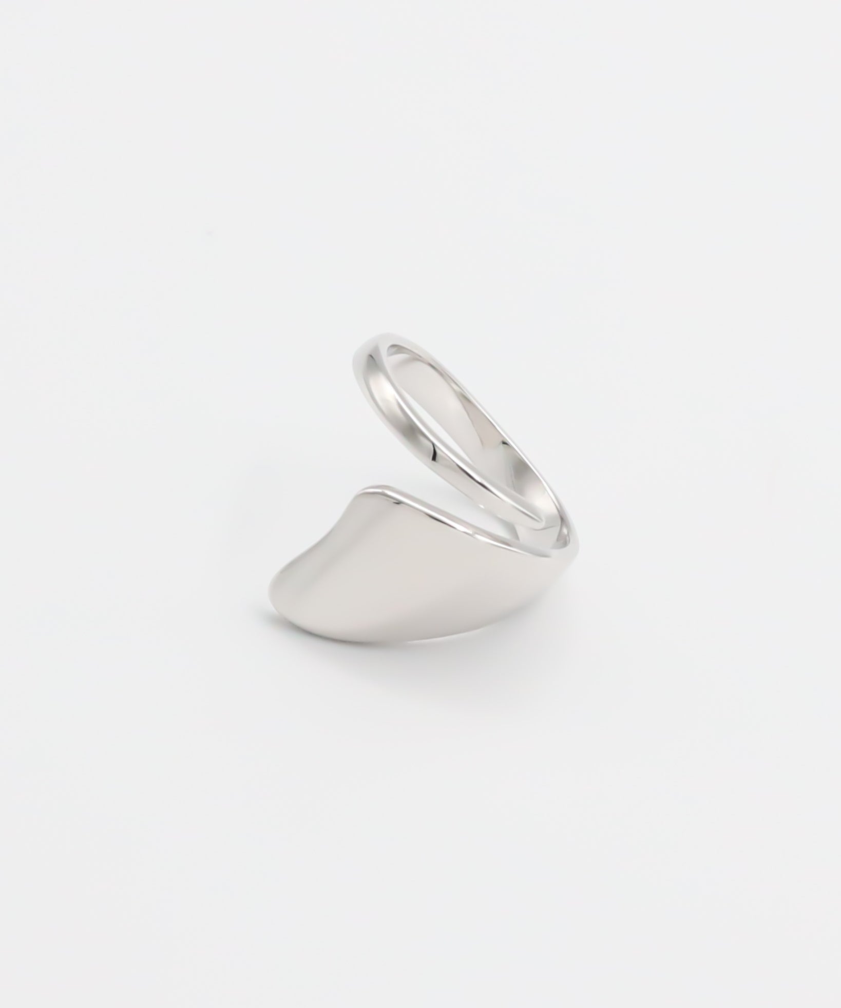 A silver ring with an abstract design on a white background.