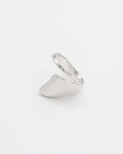 A silver ring with an abstract design on a white background.